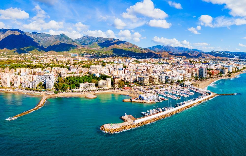 Tourists enjoying the sun on a vibrant Marbella beach.